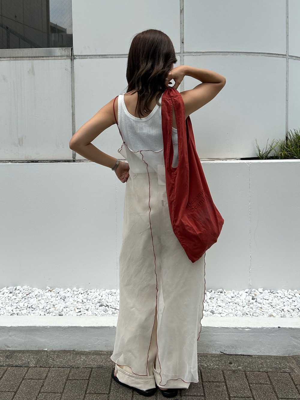 ホワイト系のタンクトップ、ホワイト系のワンピース、オレンジ系のトートバッグを着用したレディースの夏コーディネートの3枚目の写真