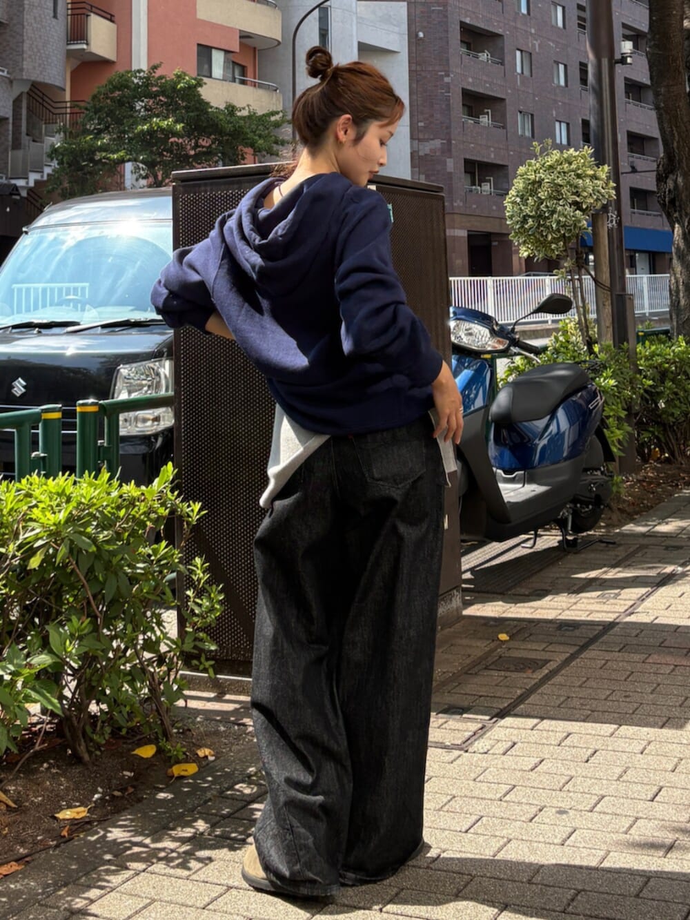 グリーン系のスリッポン、ブルー系のパーカー、ブラック系のデニムパンツを着用したレディースの秋コーディネートの4枚目の写真
