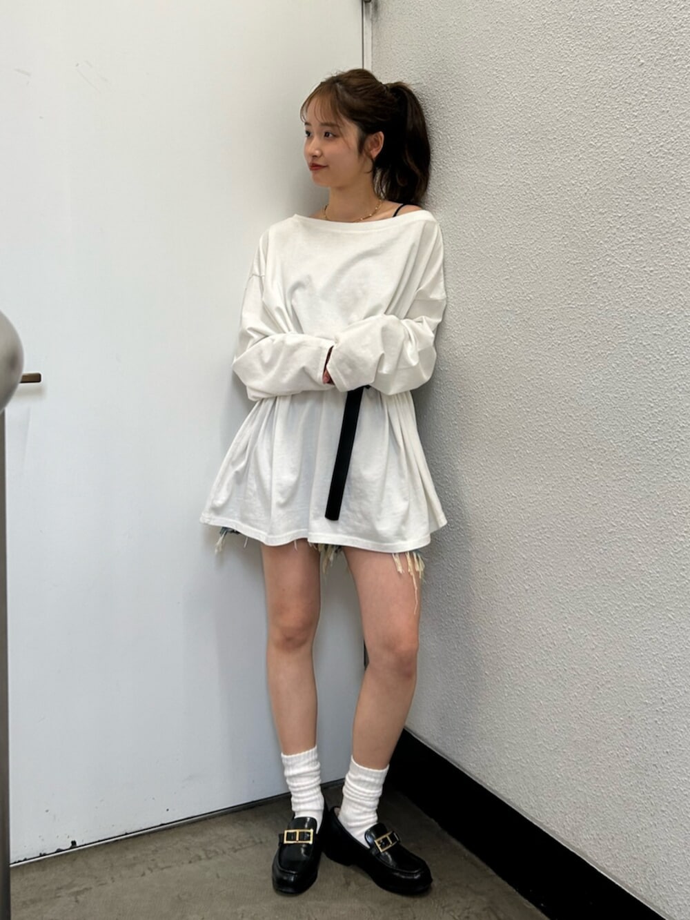 ホワイト系のTシャツ/カットソー、ブルー系のデニムパンツ、ブラック系のベルトを着用したレディースの春コーディネートの2枚目の写真