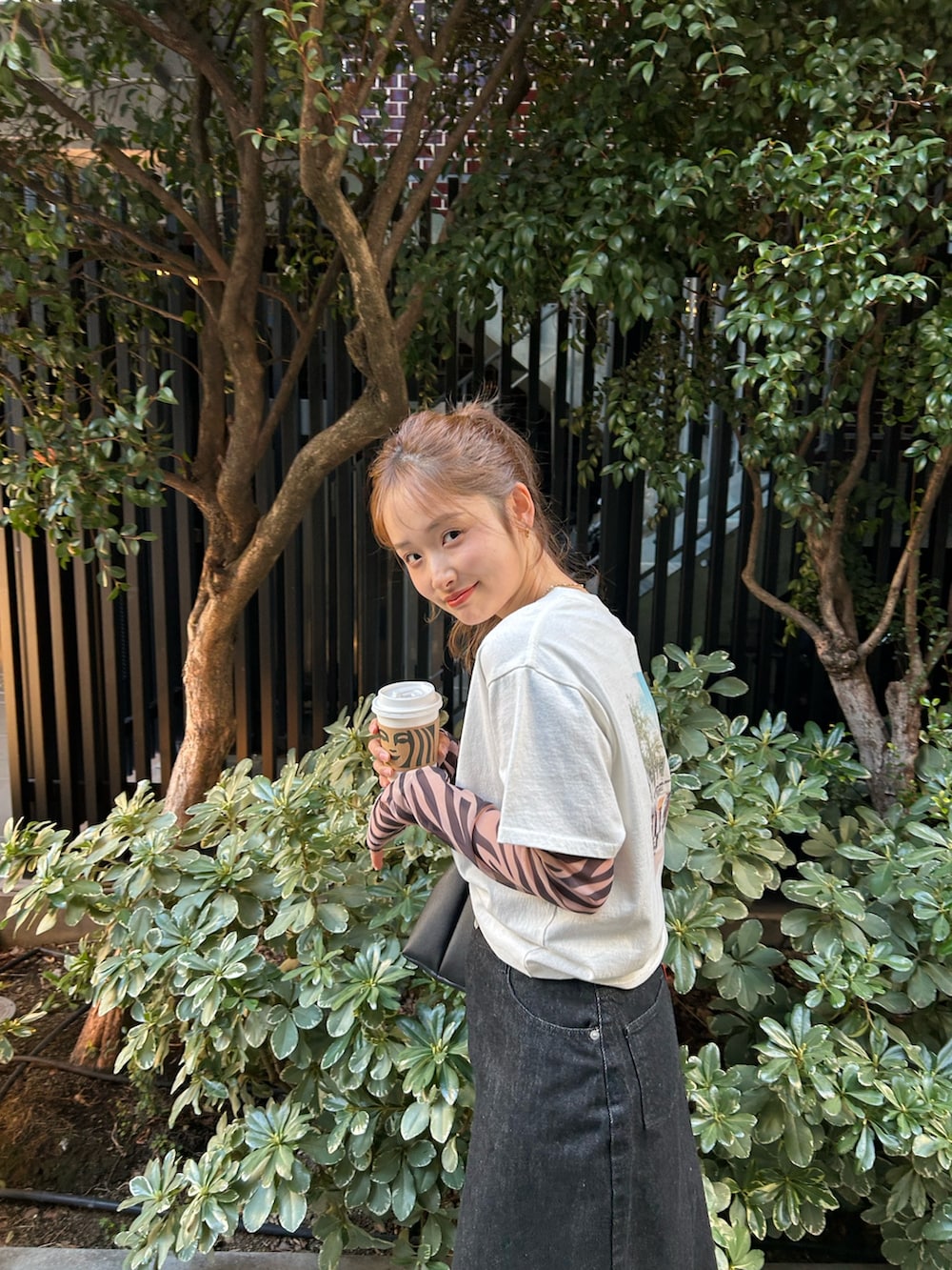 ブラック系のTシャツ/カットソー、ホワイト系のTシャツ/カットソー、ブラック系のスカートを着用したレディースの春コーディネートの7枚目の写真