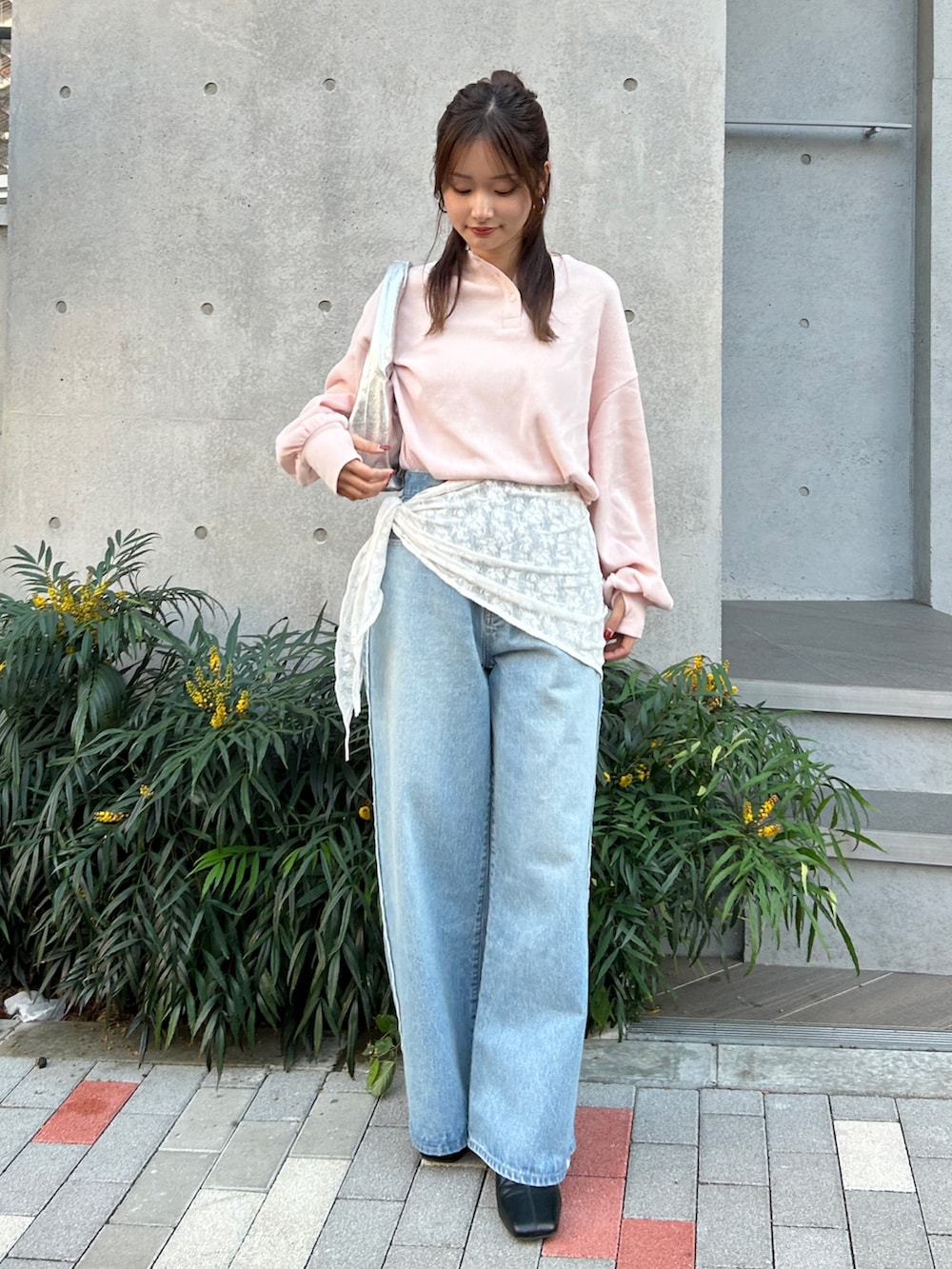 ブルー系のデニムパンツ、ブラック系のサンダル、シルバー系のハンドバッグを着用したレディースの冬コーディネートの2枚目の写真