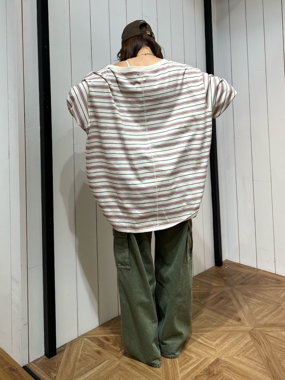 グリーン系のカーゴパンツ、ブルー系のスニーカー、ブラウン系のキャップを着用したレディースの春コーディネートの3枚目の写真