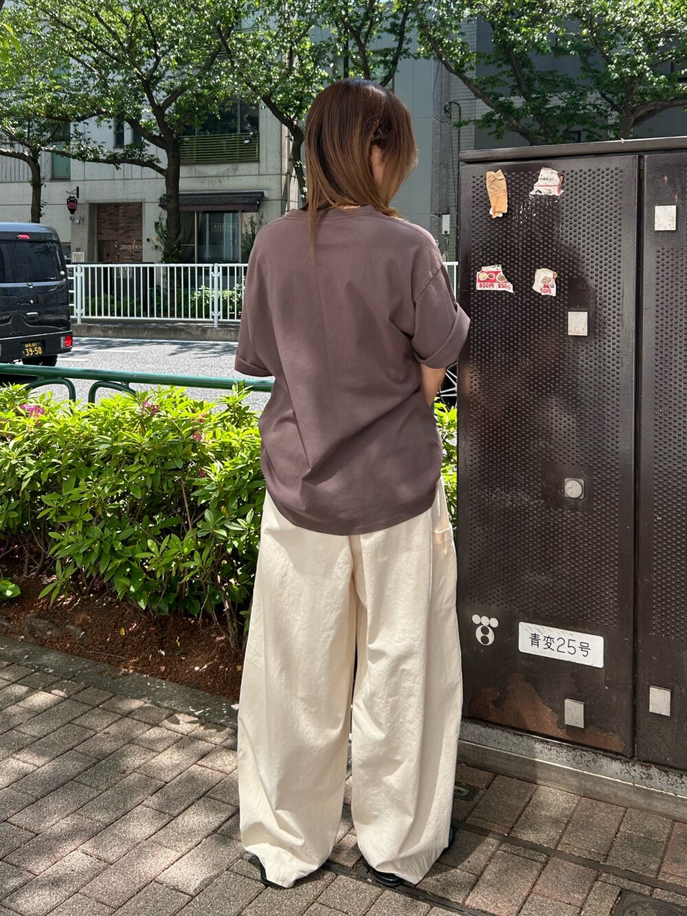 ブラウン系のTシャツ/カットソー、ブラック系のサンダル、ホワイト系のその他パンツを着用したレディースの春コーディネートの4枚目の写真