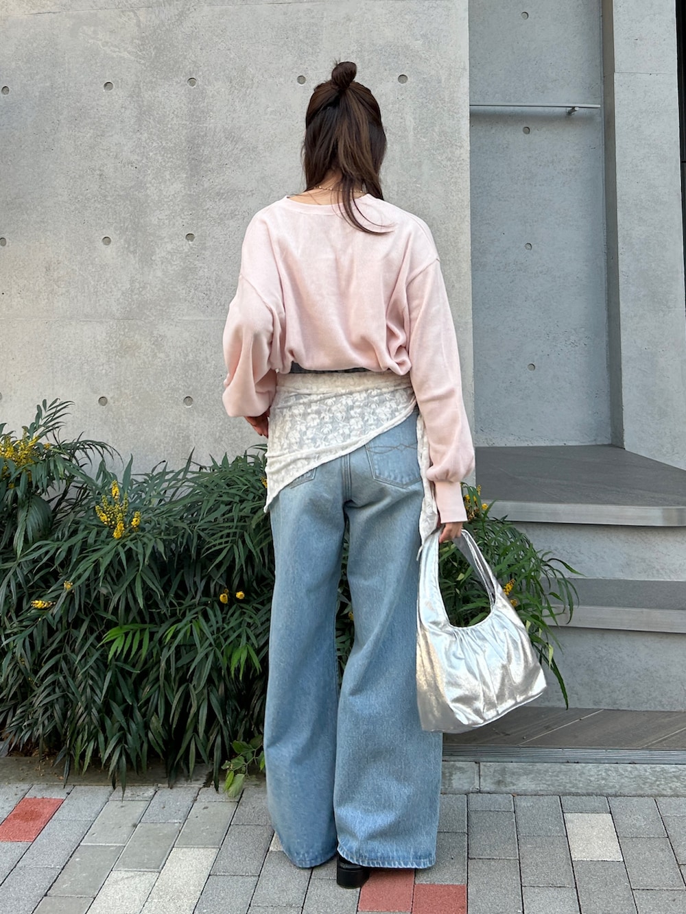 ブルー系のデニムパンツ、ブラック系のサンダル、シルバー系のハンドバッグを着用したレディースの冬コーディネートの4枚目の写真