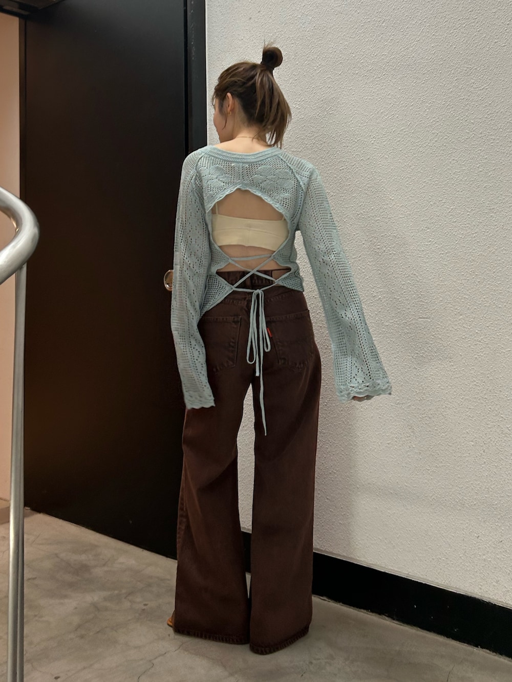 ブラウン系のデニムパンツ、ブルー系のニット/セーターを着用したレディースの春コーディネートの6枚目の写真