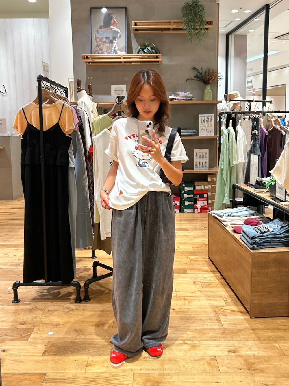 グレー系のスウェットパンツ、ブラック系のハンドバッグ、ホワイト系のTシャツ/カットソーを着用したレディースの夏コーディネートの5枚目の写真