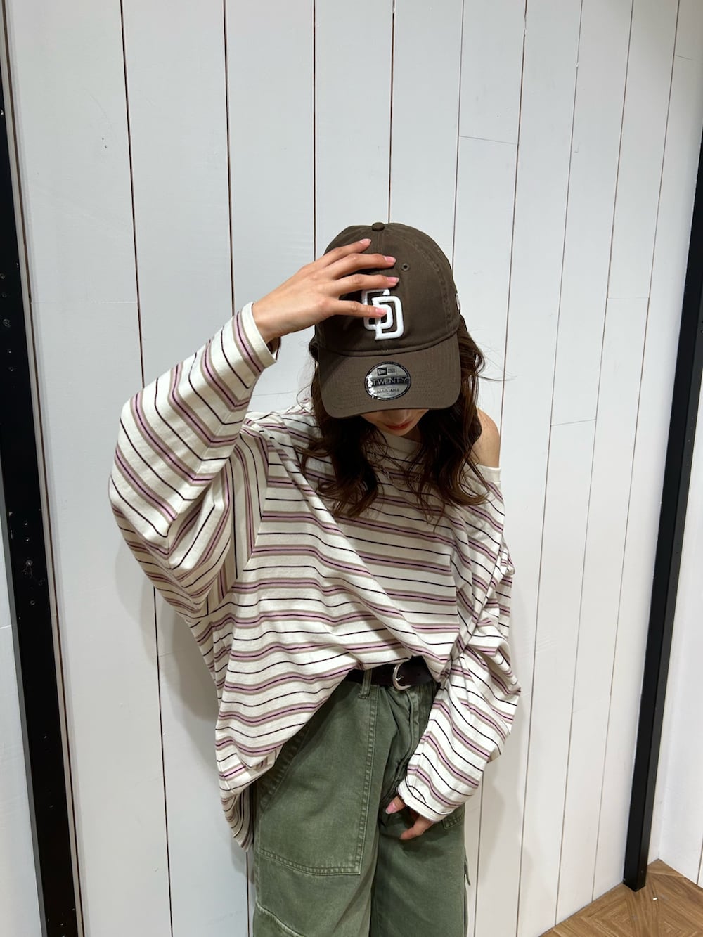 グリーン系のカーゴパンツ、ブルー系のスニーカー、ブラウン系のキャップを着用したレディースの春コーディネートの5枚目の写真