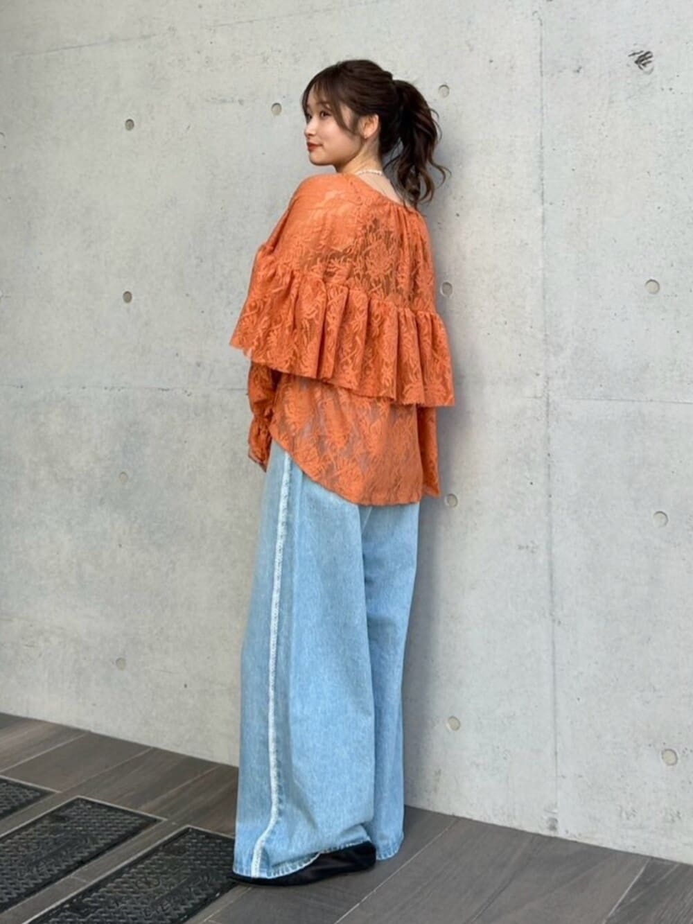 ブルー系のデニムパンツ、ブラック系のパンプス、オレンジ系のシャツ/ブラウスを着用したレディースの冬コーディネートの4枚目の写真