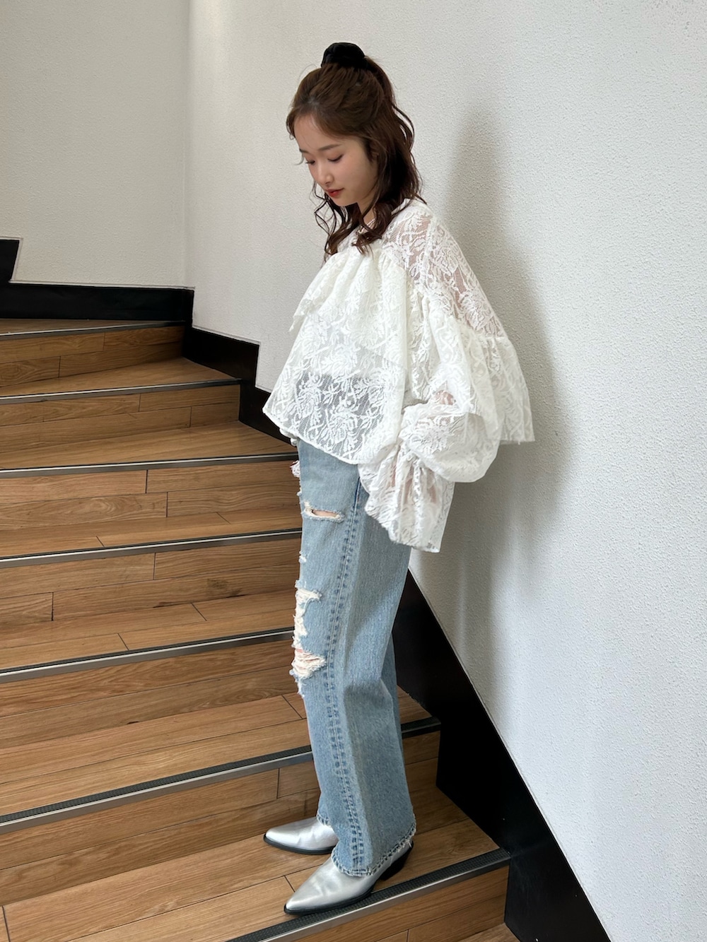 ブルー系のデニムパンツ、シルバー系のブーツ、ホワイト系のシャツ/ブラウスを着用したレディースの春コーディネートの3枚目の写真