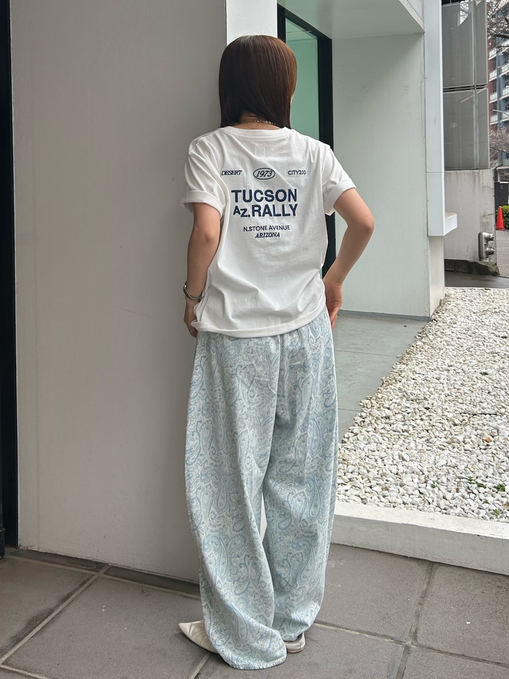 ブルー系のデニムパンツ、ホワイト系のパンプス、ホワイト系のTシャツ/カットソーを着用したレディースの春コーディネートの4枚目の写真