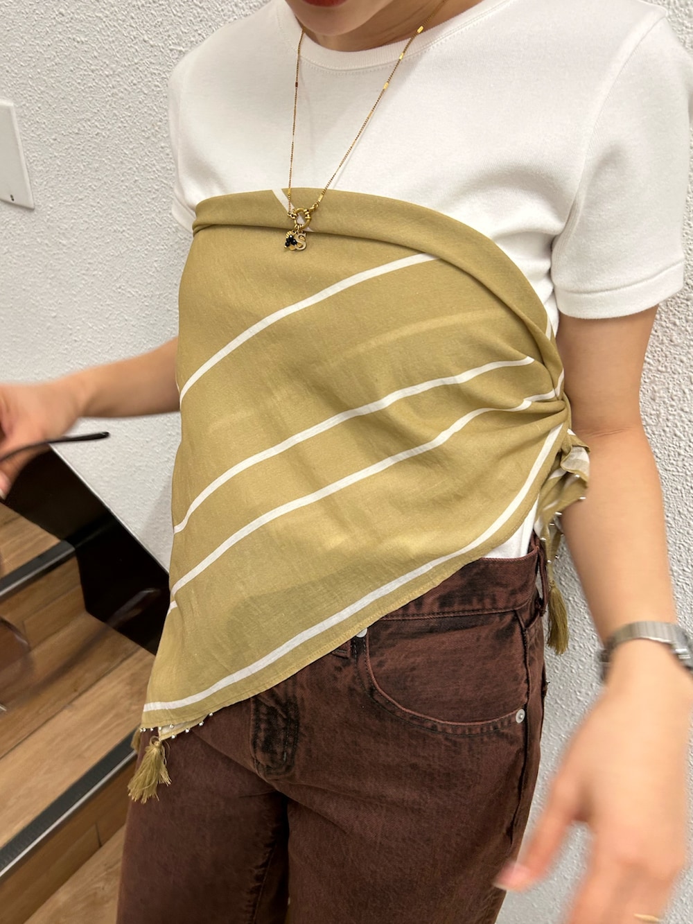 ブラウン系のデニムパンツ、ホワイト系のTシャツ/カットソー、イエロー系のバンダナ/スカーフを着用したレディースの春コーディネートの7枚目の写真