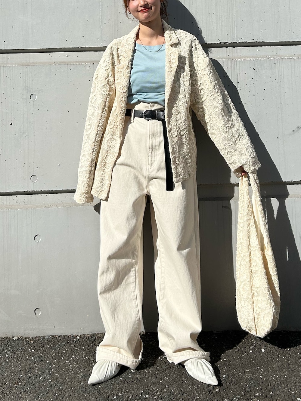 ブルー系のTシャツ/カットソー、ホワイト系のデニムパンツ、ホワイト系のパンプスを着用したレディースの冬コーディネートの6枚目の写真