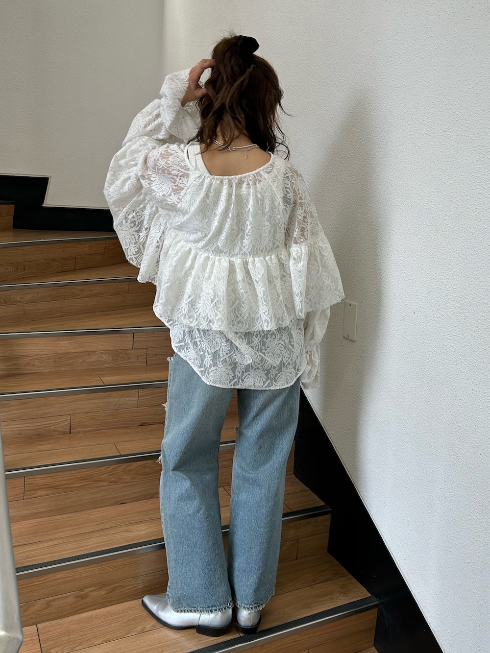 ブルー系のデニムパンツ、シルバー系のブーツ、ホワイト系のシャツ/ブラウスを着用したレディースの春コーディネートの4枚目の写真