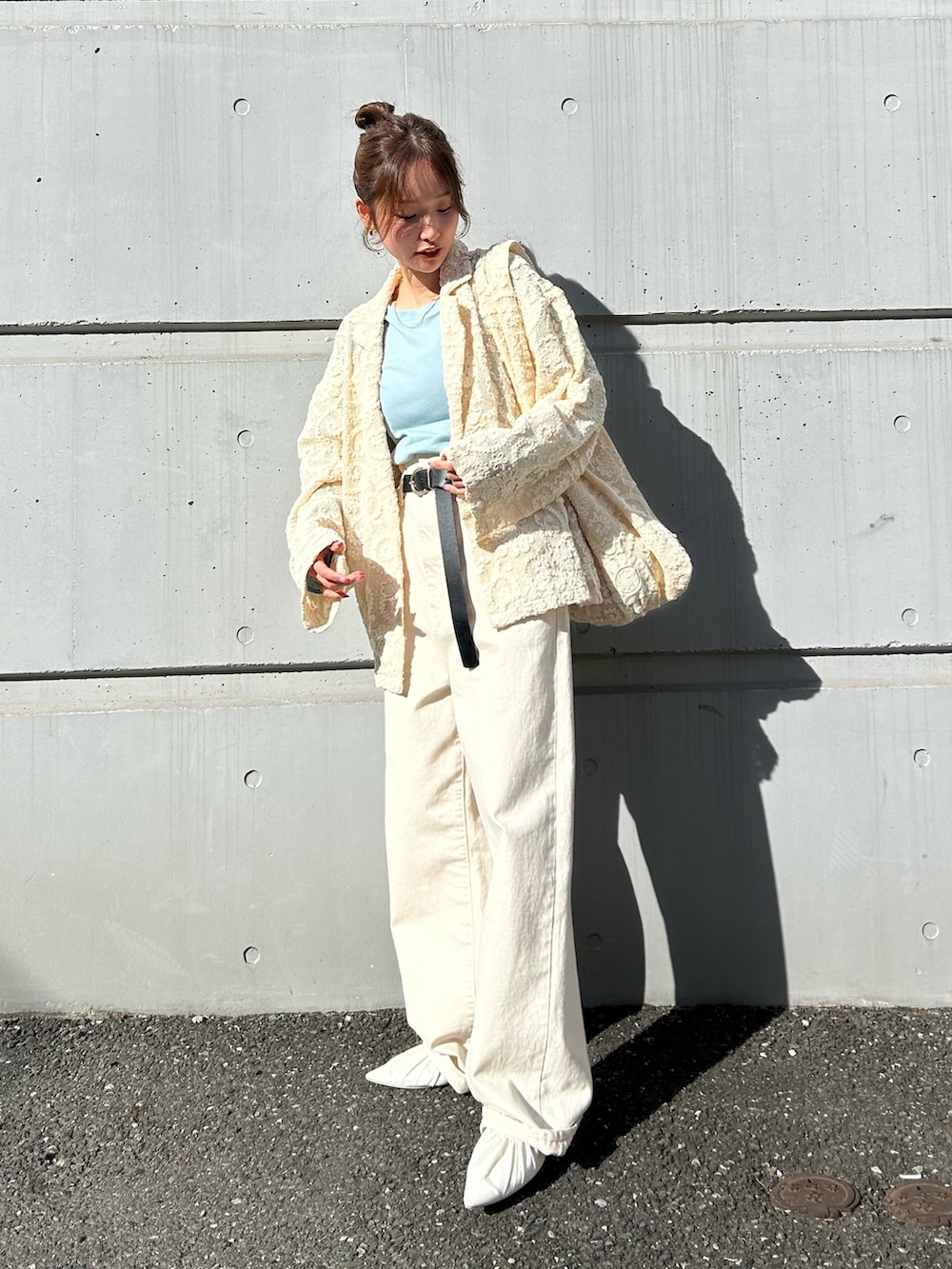 ブルー系のTシャツ/カットソー、ホワイト系のデニムパンツ、ホワイト系のパンプスを着用したレディースの冬コーディネートの4枚目の写真