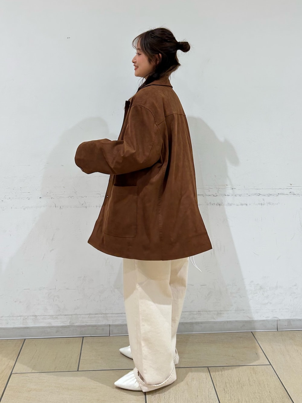 ブラウン系のテーラードジャケット、ホワイト系のパンプス、ホワイト系のデニムパンツを着用したレディースの冬コーディネートの3枚目の写真