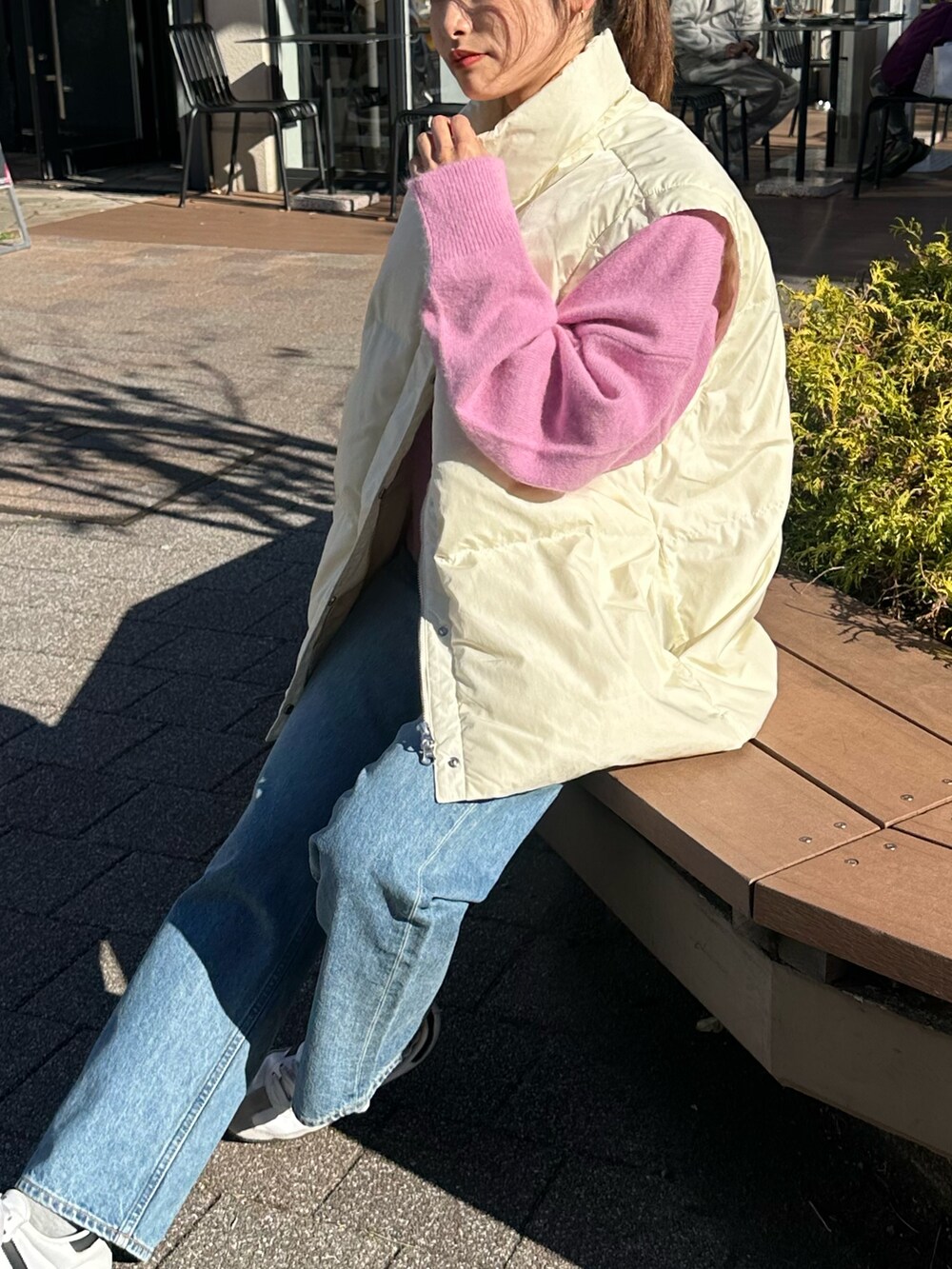 ブルー系のデニムパンツ、ピンク系のニット/セーター、ホワイト系のダウンジャケット/コートを着用したレディースの冬コーディネートの6枚目の写真