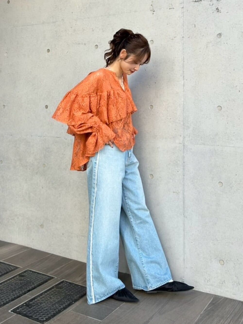 ブルー系のデニムパンツ、ブラック系のパンプス、オレンジ系のシャツ/ブラウスを着用したレディースの冬コーディネートの2枚目の写真