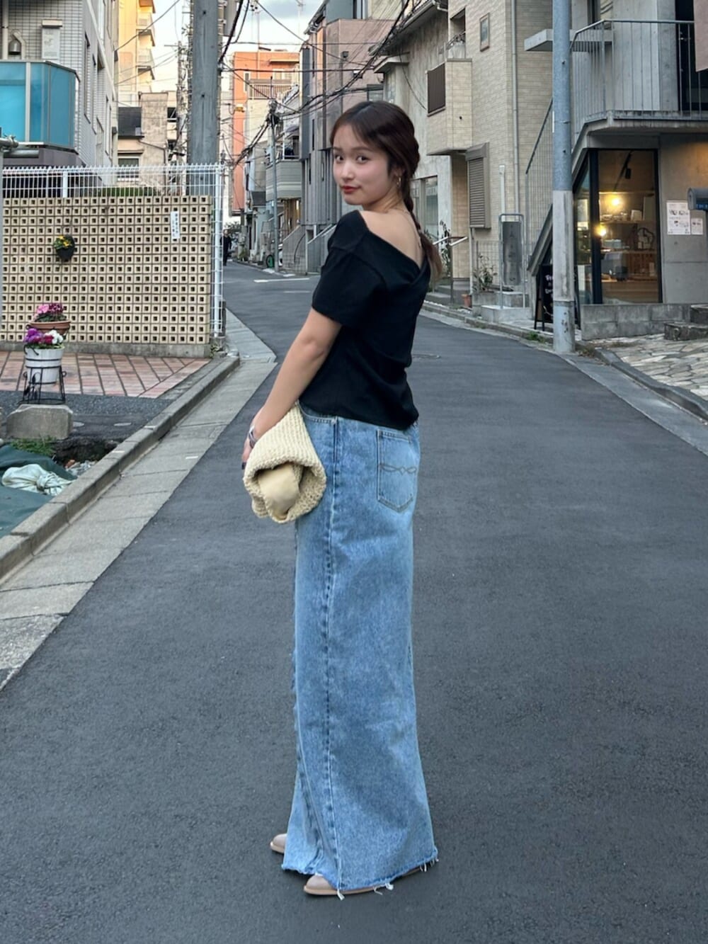 ブルー系のスカート、ベージュ系のハンドバッグ、ベージュ系のブーツを着用したレディースの冬コーディネートの3枚目の写真