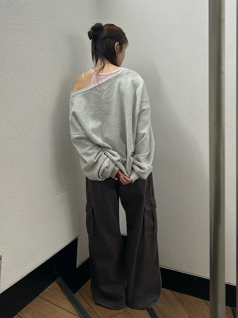 グレー系のスウェット、ブラウン系のカーゴパンツ、ピンク系のキャミソールを着用したレディースの春コーディネートの4枚目の写真