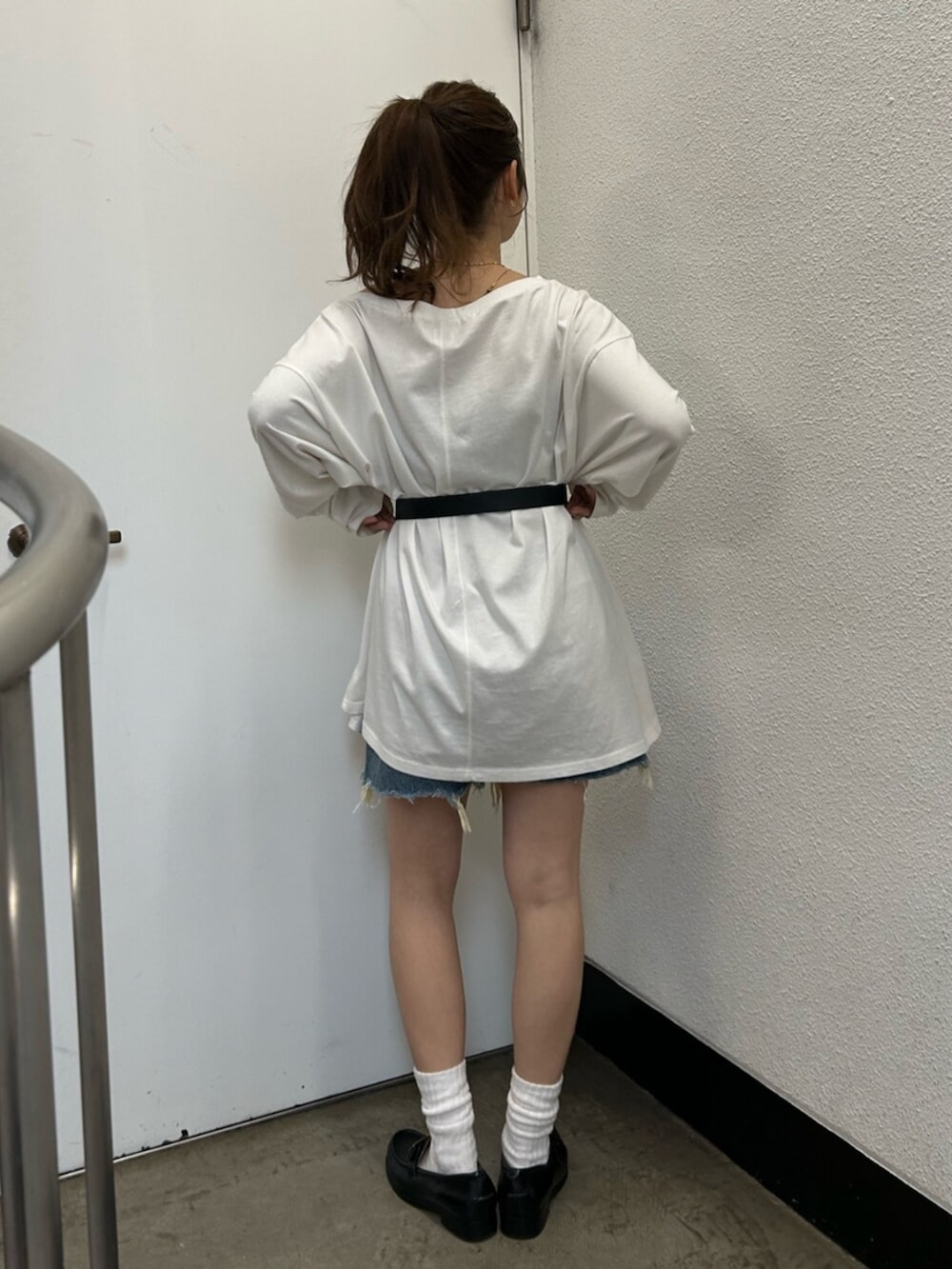 ホワイト系のTシャツ/カットソー、ブルー系のデニムパンツ、ブラック系のベルトを着用したレディースの春コーディネートの4枚目の写真