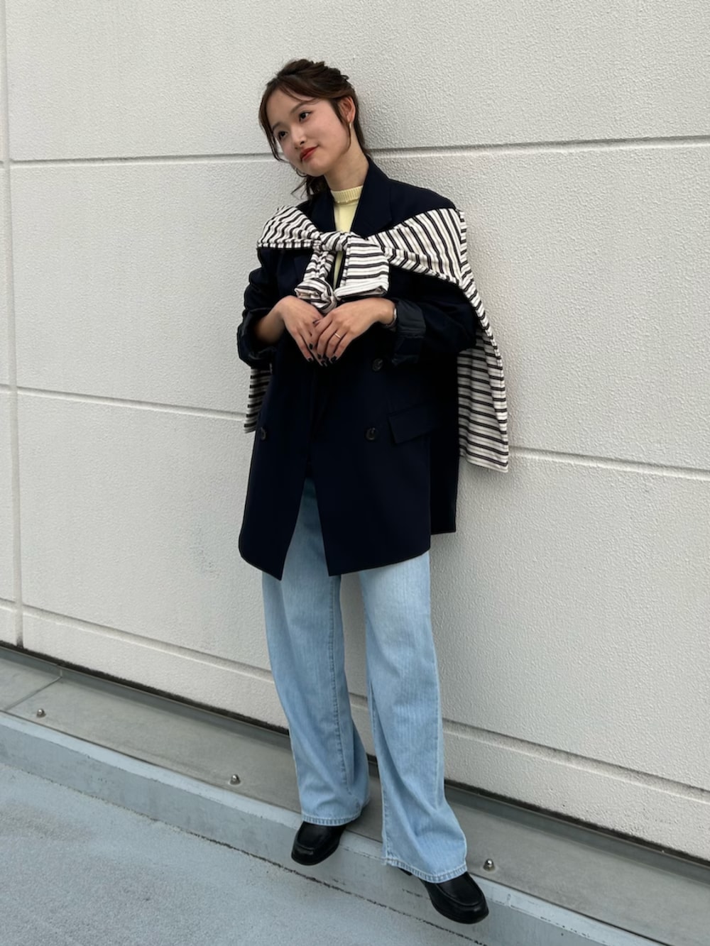 イエロー系のニット/セーター、ブルー系のテーラードジャケット、ブルー系のデニムパンツを着用したレディースの冬コーディネートの6枚目の写真