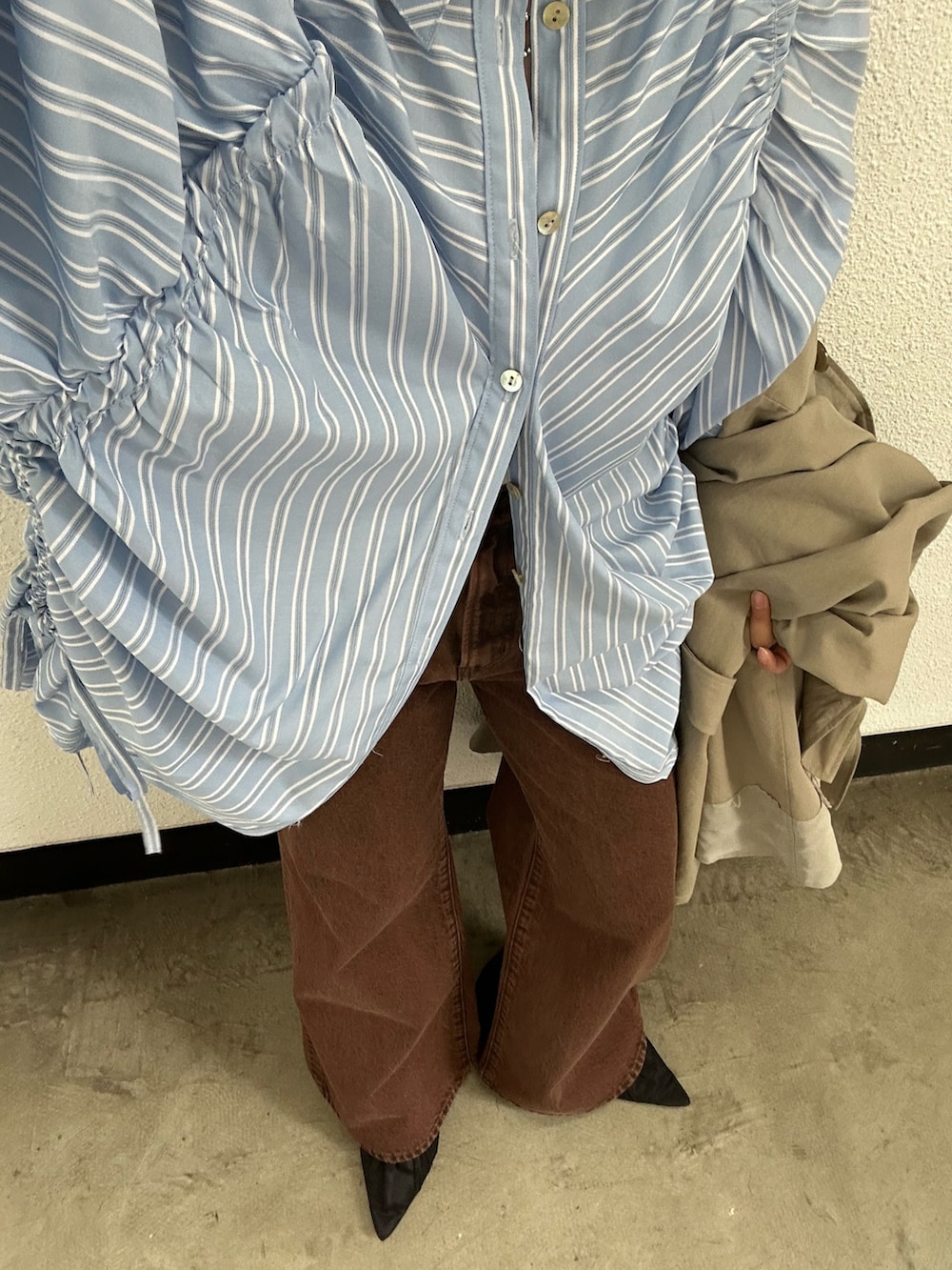 グリーン系のトレンチコート、ブラック系のパンプス、ブルー系のシャツ/ブラウスを着用したレディースの春コーディネートの7枚目の写真