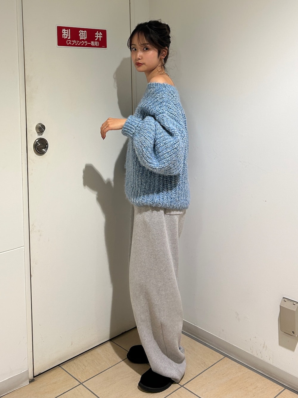 ブルー系のニット/セーター、グレー系のその他パンツ、ブラック系のスリッポンを着用したレディースの冬コーディネートの6枚目の写真