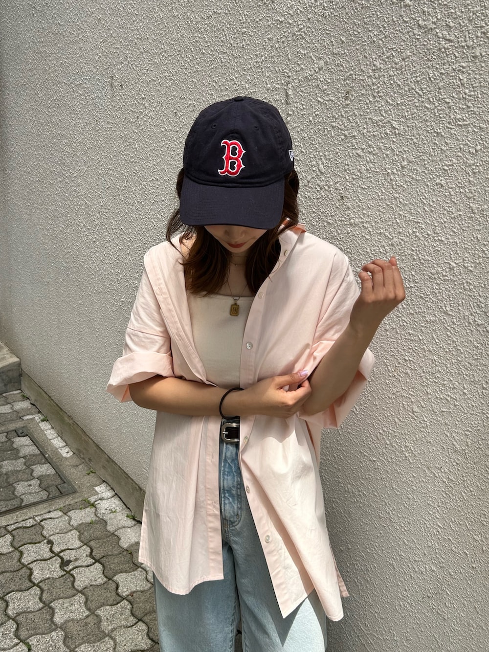 ブルー系のデニムパンツ、ピンク系のシャツ/ブラウス、ホワイト系のキャミソールを着用したレディースの春コーディネートの5枚目の写真