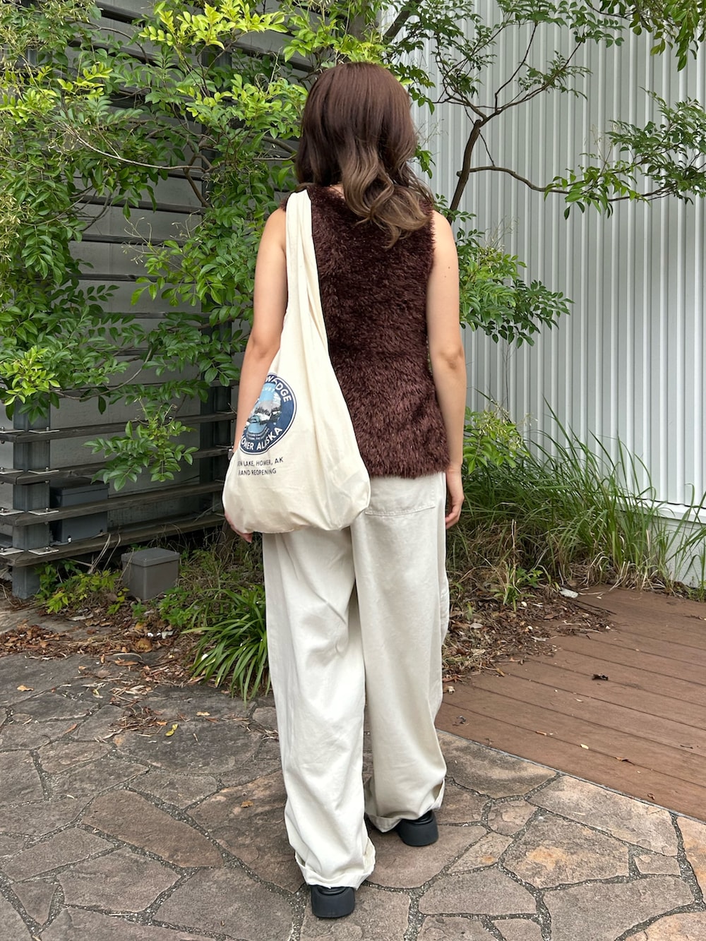 ブラウン系のニット/セーター、ホワイト系のその他パンツ、ホワイト系のトートバッグを着用したレディースの夏コーディネートの3枚目の写真