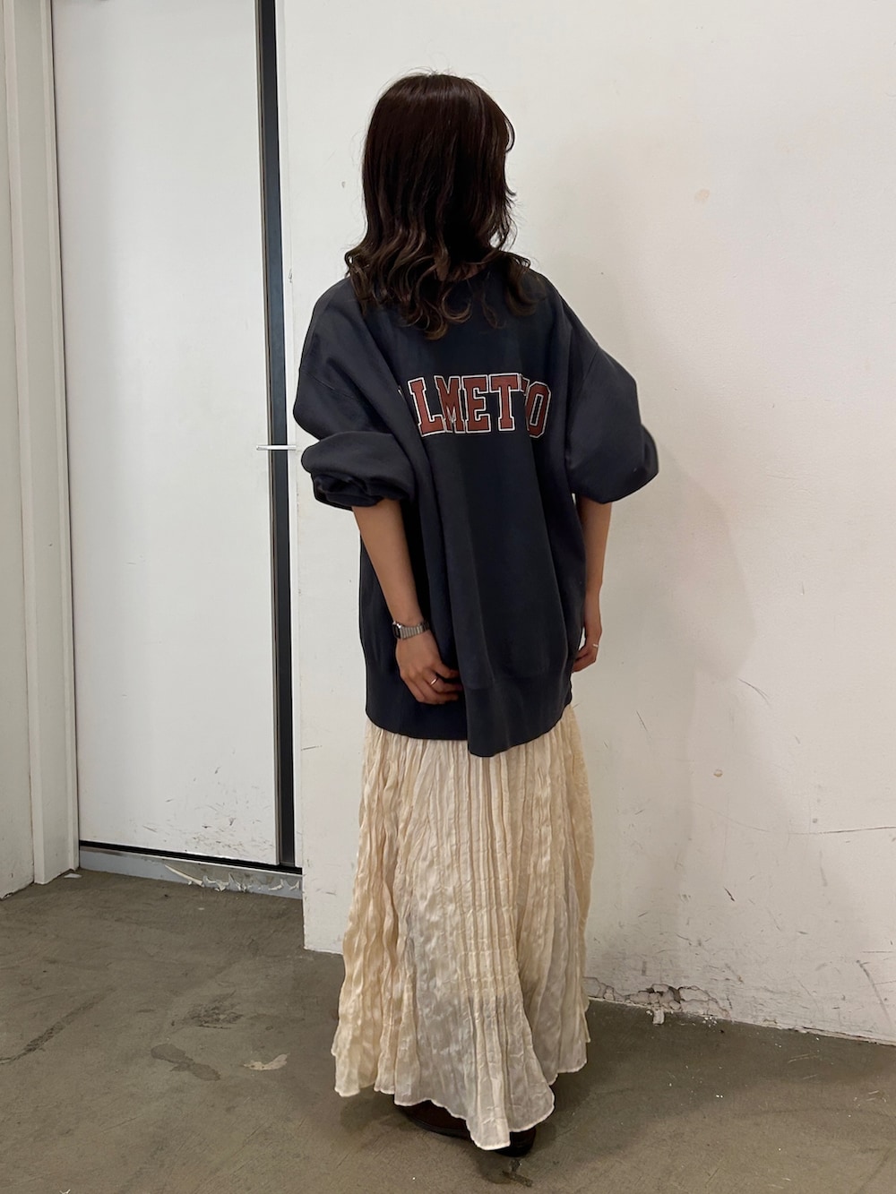 グレー系のスウェット、ホワイト系のスカート、ブラウン系のブーツを着用したレディースの秋コーディネートの3枚目の写真