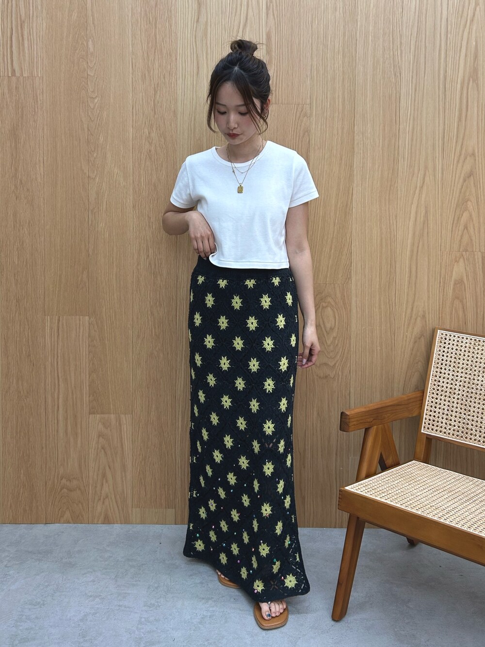 グレー系のスカート、ホワイト系のTシャツ/カットソー、シルバー系のサンダルを着用したレディースの春コーディネートの2枚目の写真