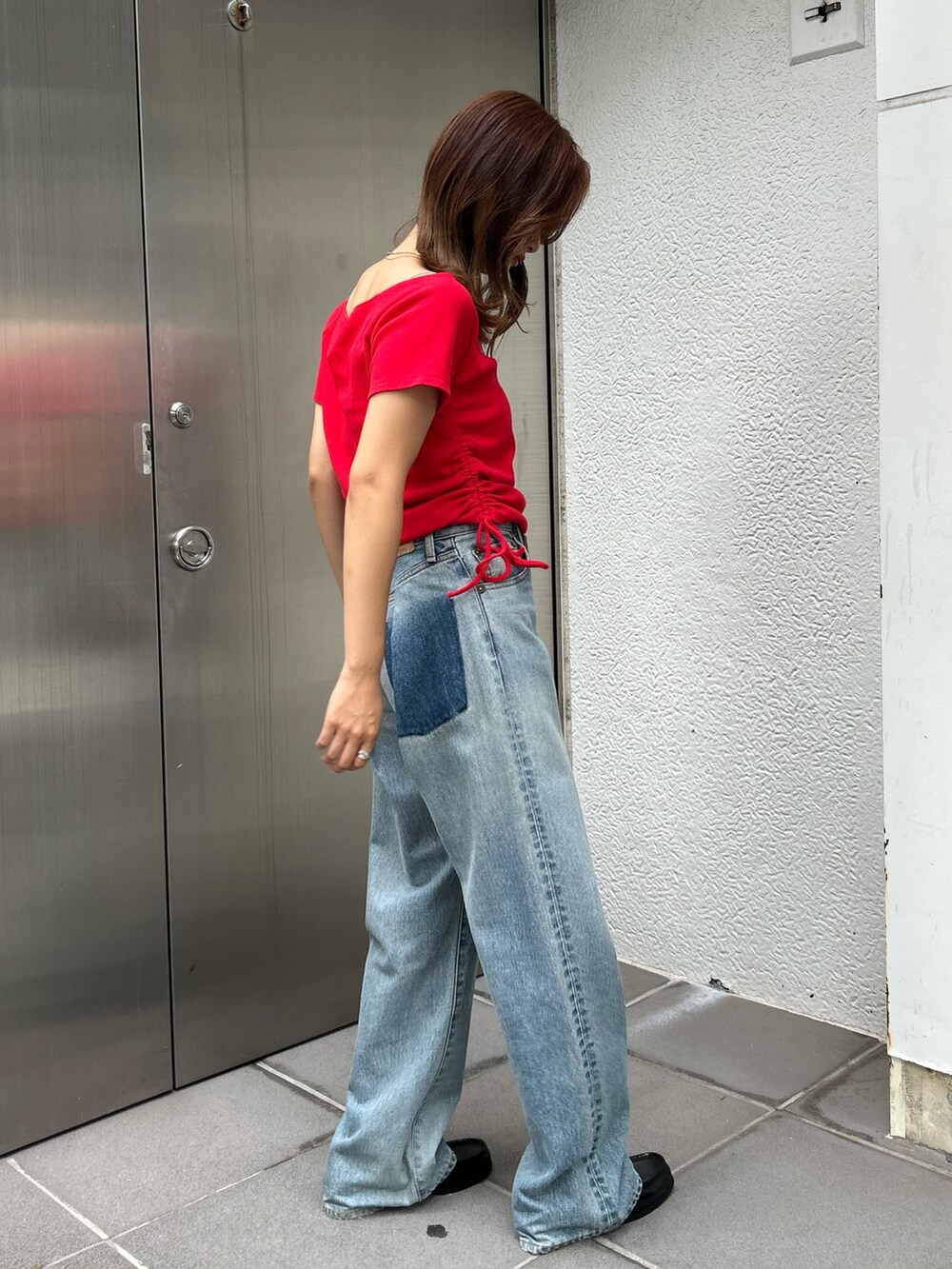 レッド系のTシャツ/カットソー、ブルー系のデニムパンツを着用したレディースの夏コーディネートの4枚目の写真