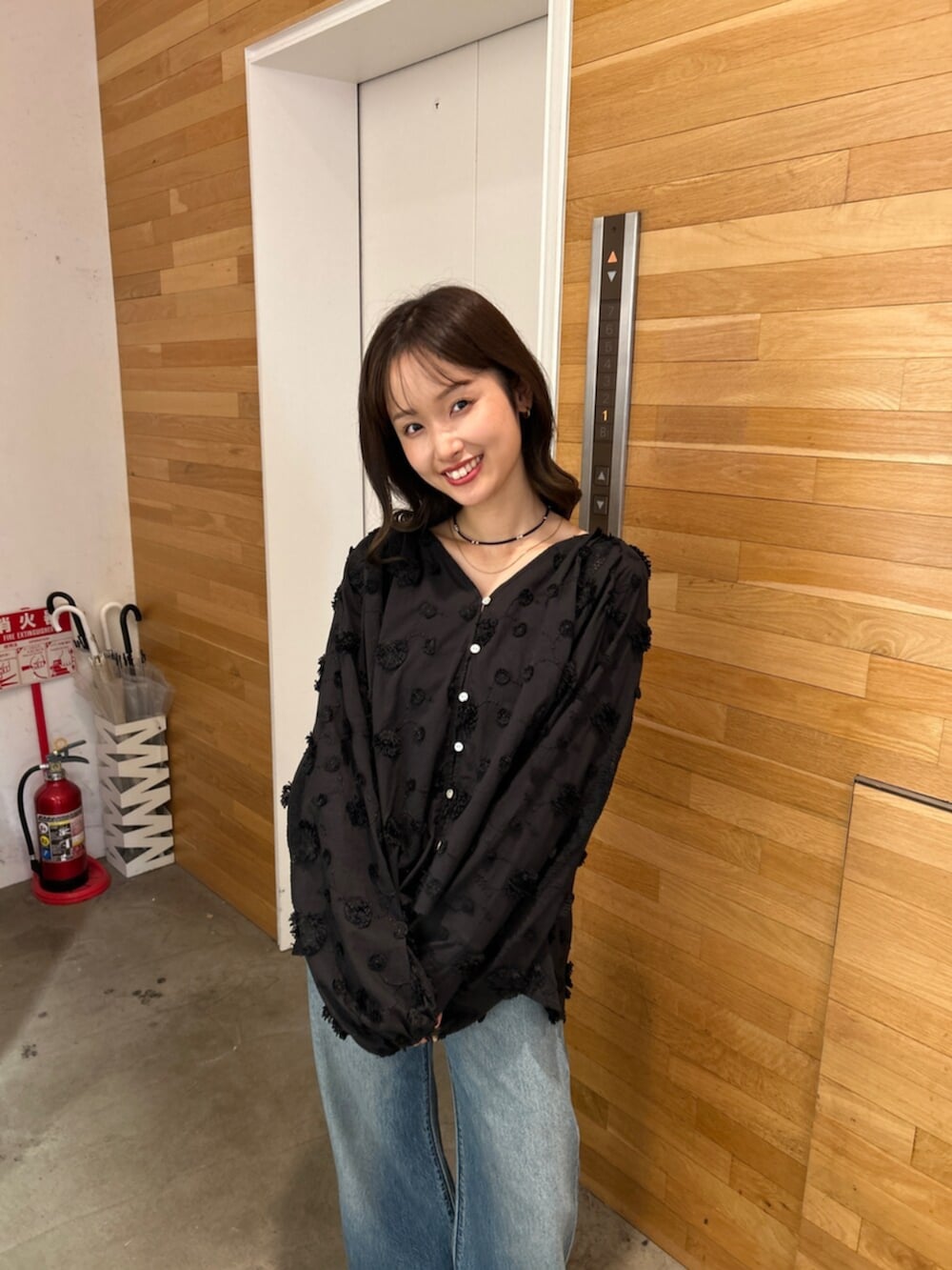 ブルー系のデニムパンツ、ブラック系のシャツ/ブラウス、ベージュ系のローファーを着用したレディースの秋コーディネートの6枚目の写真