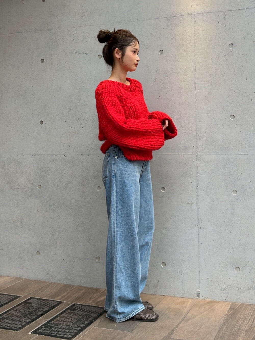 ブルー系のデニムパンツ、レッド系のニット/セーターを着用したレディースの秋コーディネートの2枚目の写真
