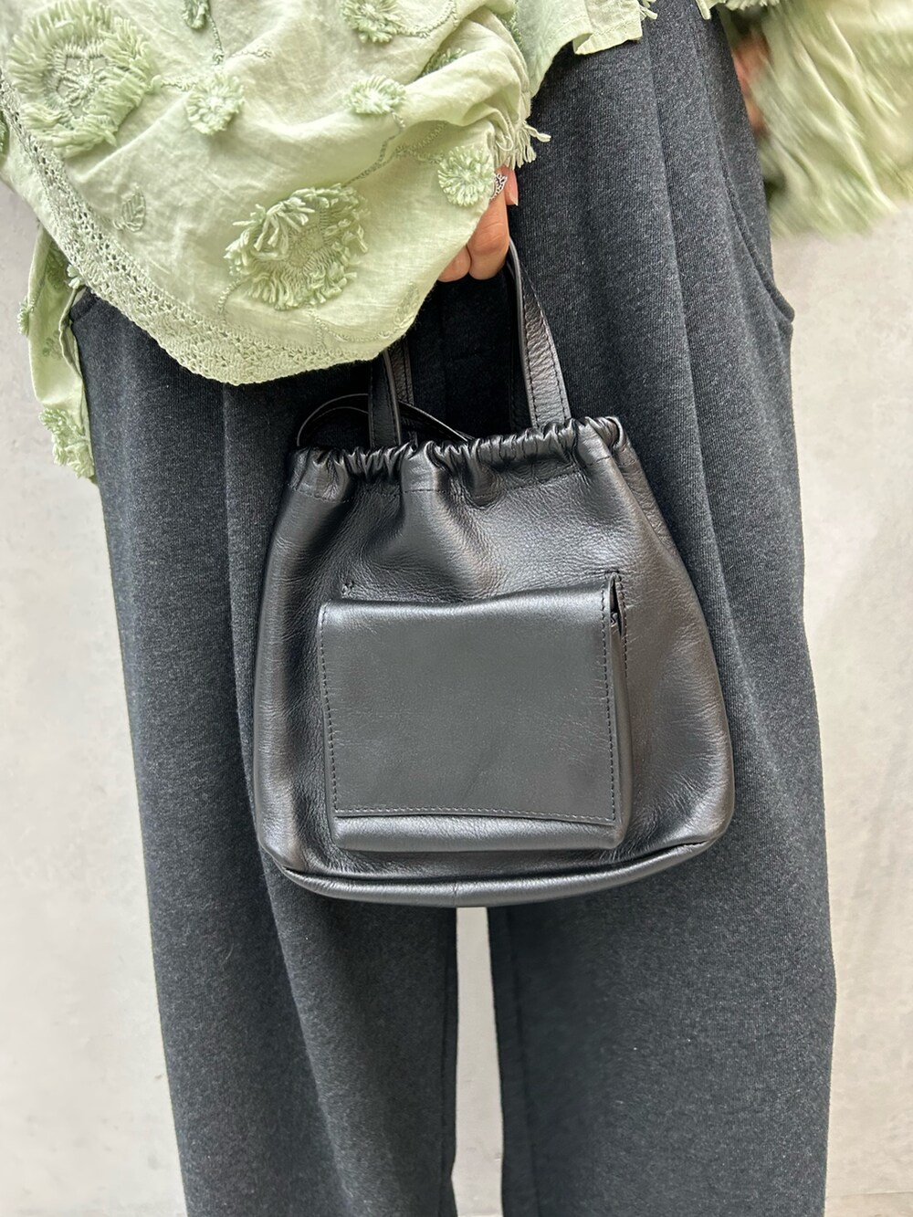 グレー系のスウェットパンツ、ブラック系のスリッポン、グリーン系のシャツ/ブラウスを着用したレディースの秋コーディネートの5枚目の写真