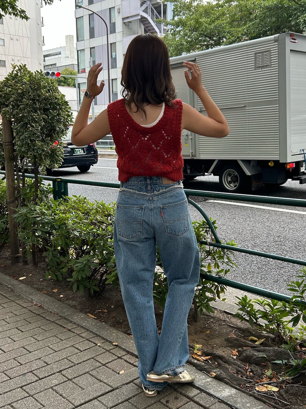 ブルー系のデニムパンツ、ゴールド系のバレエシューズ、オレンジ系のワンピースを着用したレディースの夏コーディネートの4枚目の写真