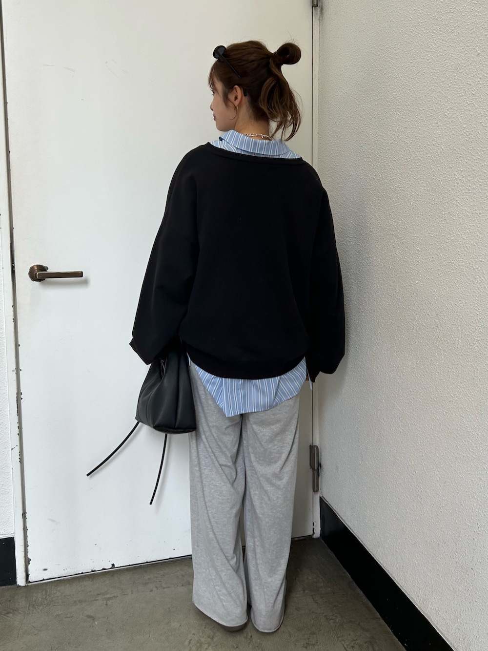 ブラック系のスウェット、ブルー系のシャツ/ブラウス、ブラック系のハンドバッグを着用したレディースの春コーディネートの4枚目の写真