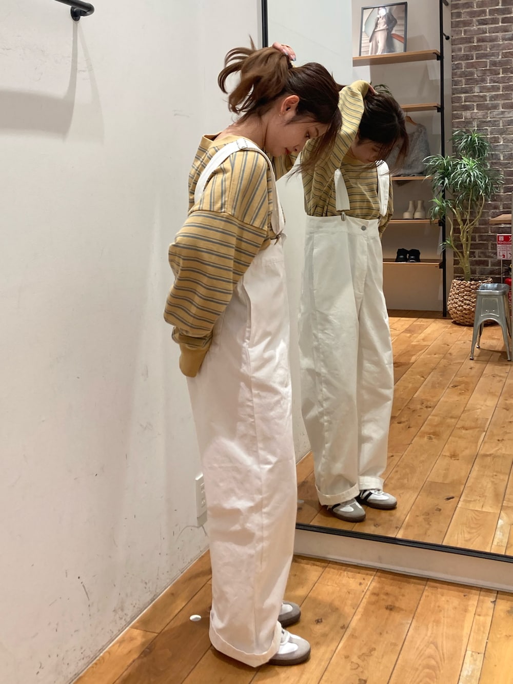 イエロー系のTシャツ/カットソー、ホワイト系のつなぎ/オールインワンを着用したレディースの冬コーディネートの4枚目の写真