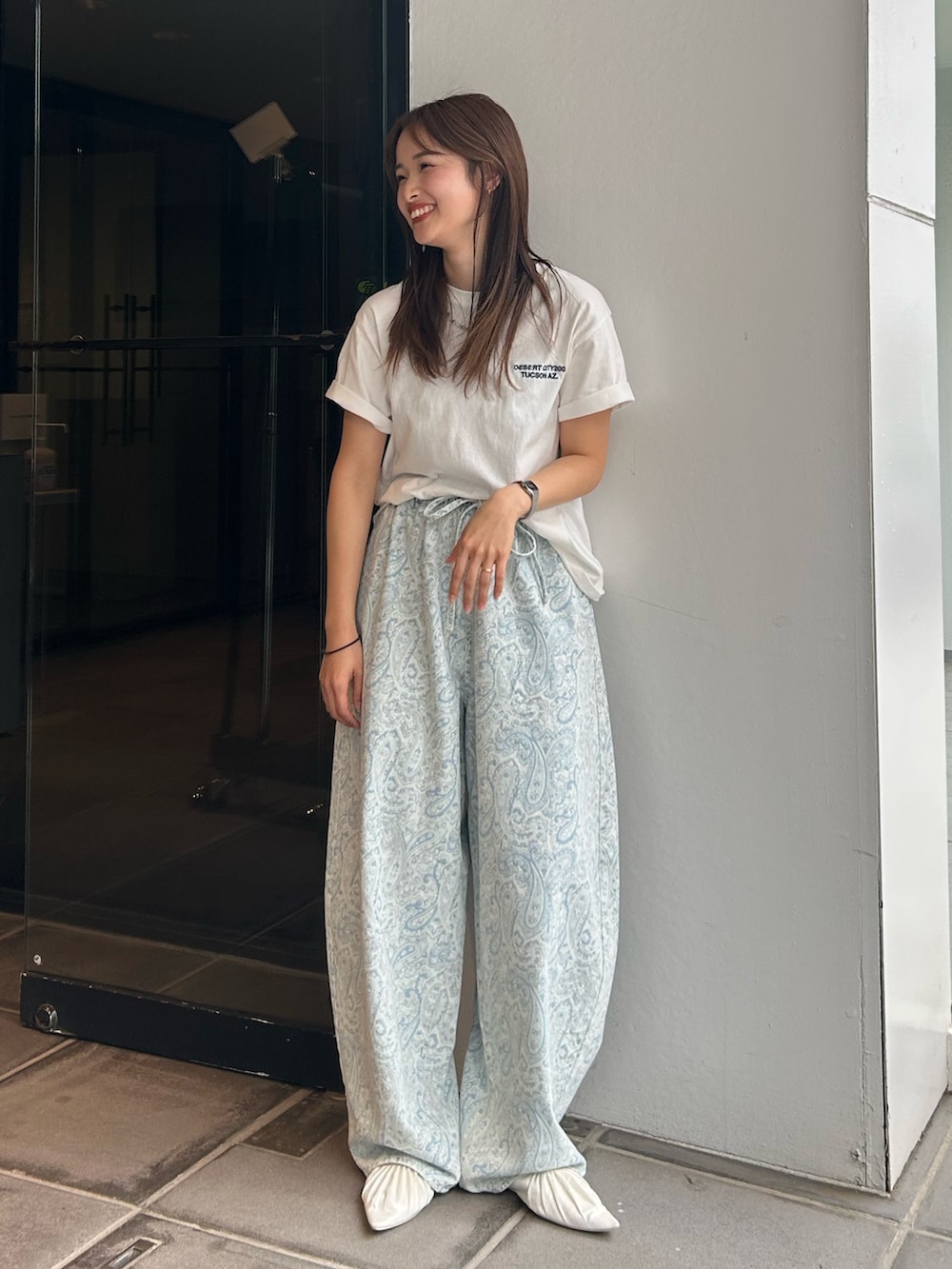 ブルー系のデニムパンツ、ホワイト系のパンプス、ホワイト系のTシャツ/カットソーを着用したレディースの春コーディネートの8枚目の写真