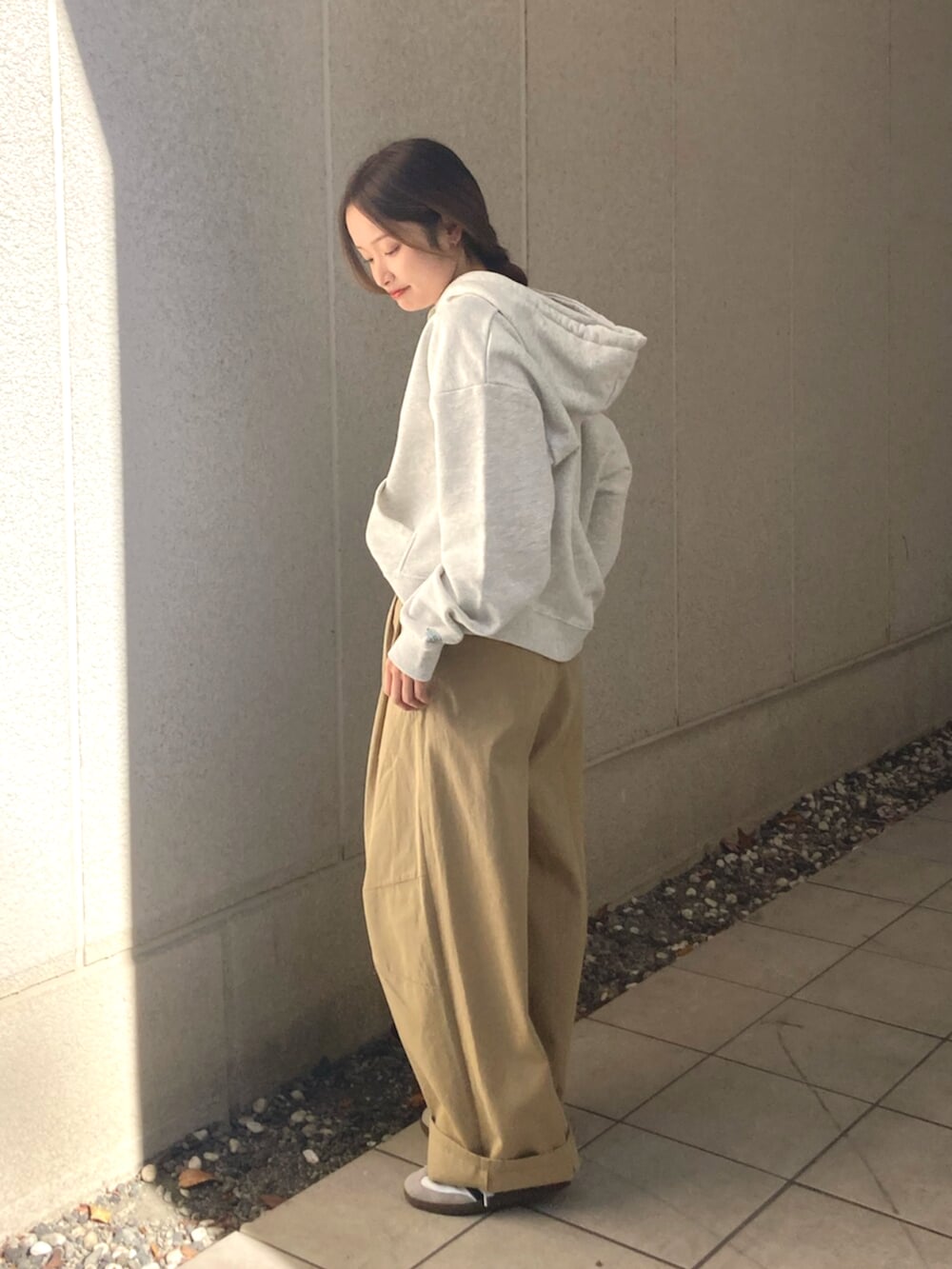 ベージュ系のチノパンツ、グレー系のパーカーを着用したレディースの冬コーディネートの3枚目の写真
