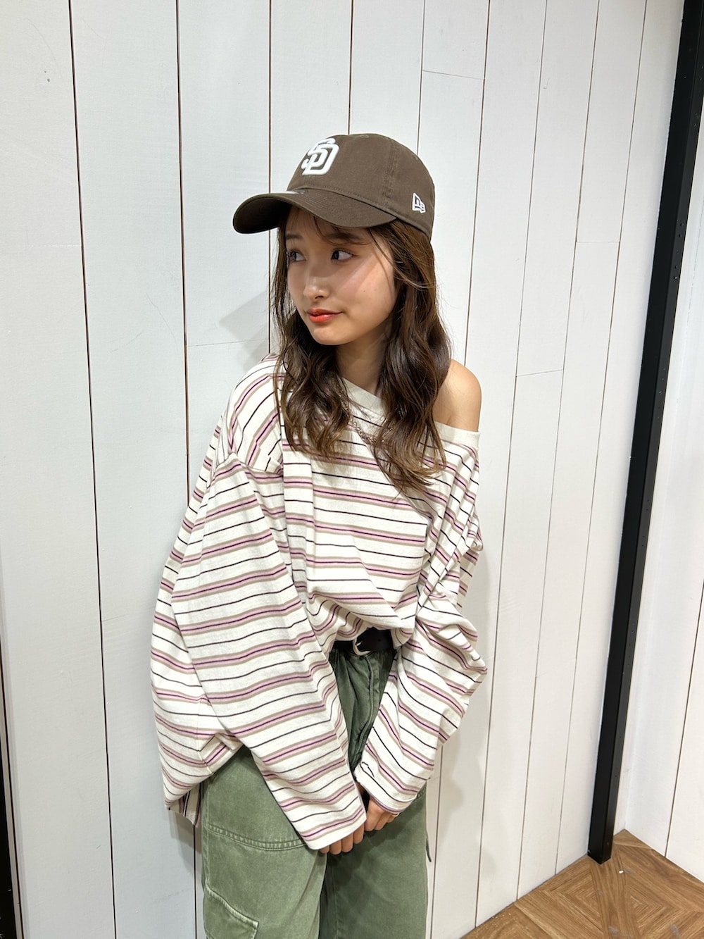 グリーン系のカーゴパンツ、ブルー系のスニーカー、ブラウン系のキャップを着用したレディースの春コーディネートの4枚目の写真