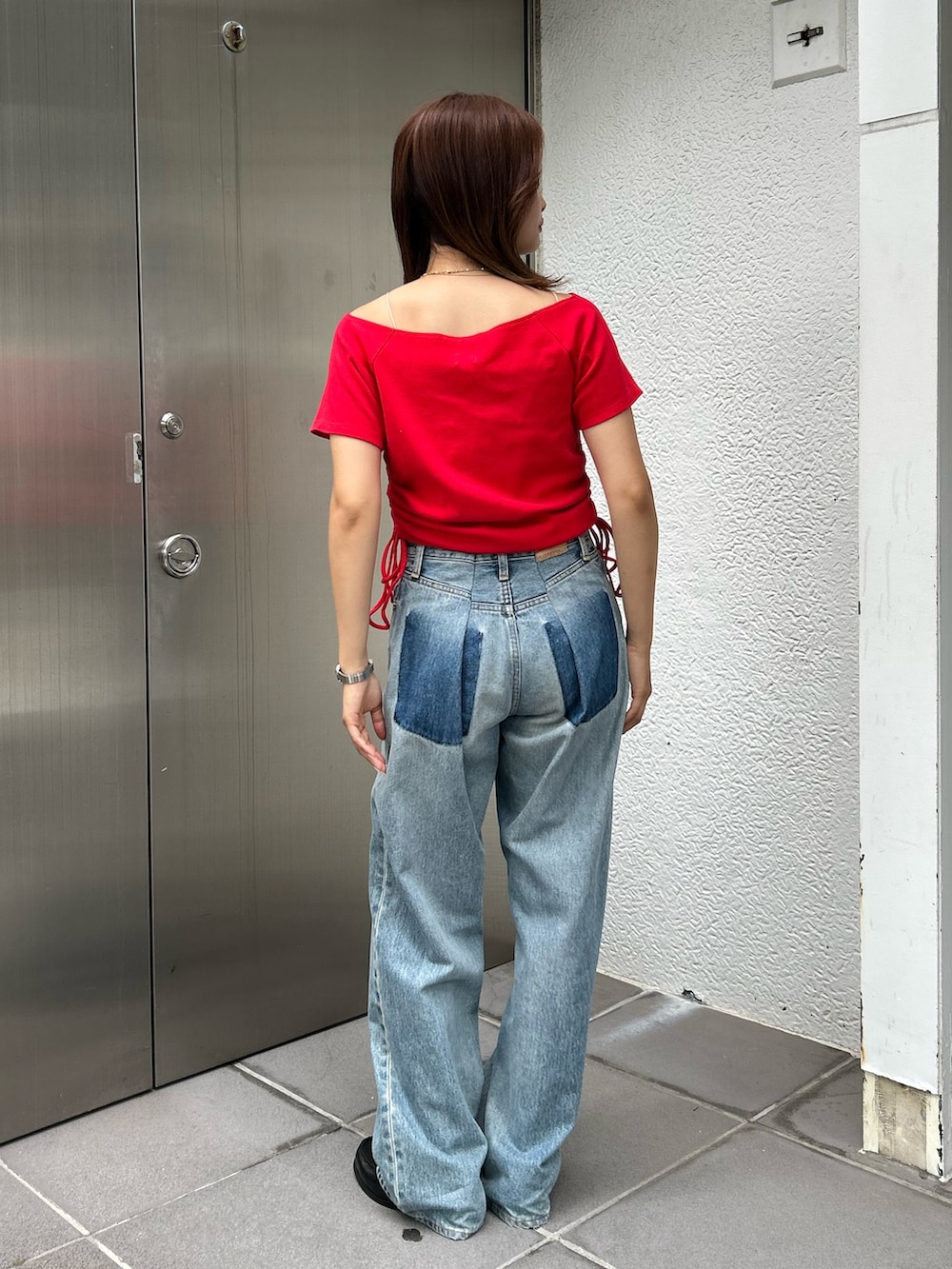 レッド系のTシャツ/カットソー、ブルー系のデニムパンツを着用したレディースの夏コーディネートの3枚目の写真