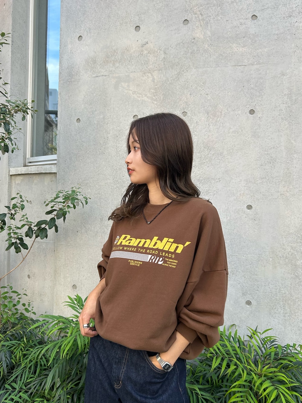 ブルー系のデニムパンツ、ブラック系のスリッポン、ブラウン系のスウェットを着用したレディースの冬コーディネートの8枚目の写真