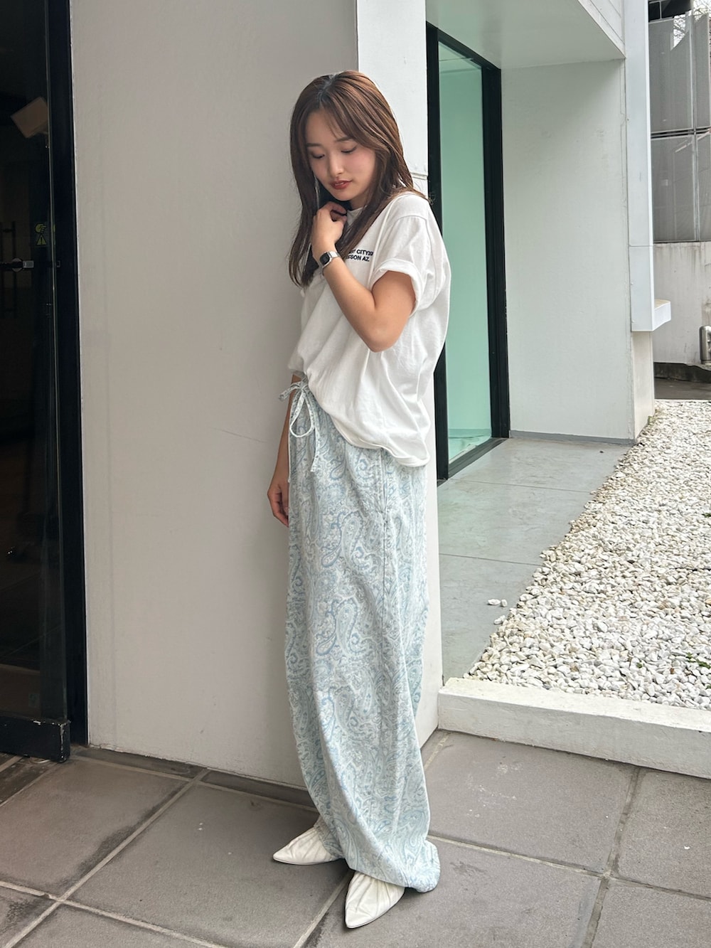 ブルー系のデニムパンツ、ホワイト系のパンプス、ホワイト系のTシャツ/カットソーを着用したレディースの春コーディネートの3枚目の写真