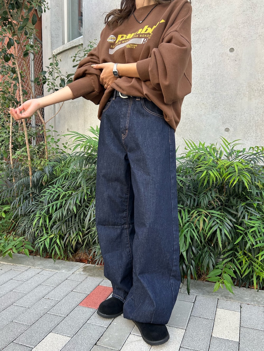 ブルー系のデニムパンツ、ブラック系のスリッポン、ブラウン系のスウェットを着用したレディースの冬コーディネートの6枚目の写真