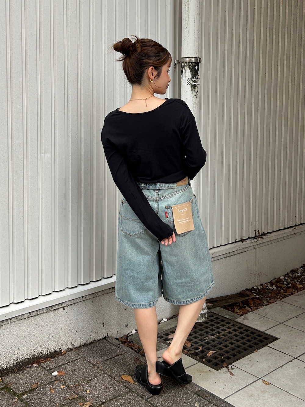 ブラック系のその他シューズ、ブラック系のTシャツ/カットソー、ブルー系のデニムパンツを着用したレディースの夏コーディネートの3枚目の写真