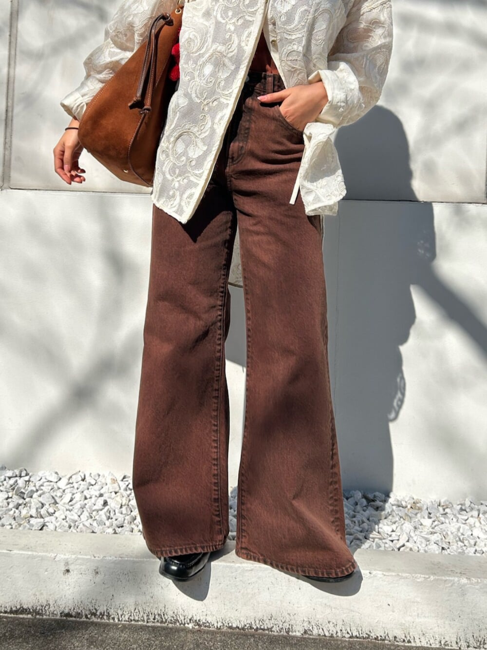 ブラウン系のキャミソール、ホワイト系のシャツ/ブラウス、ブラウン系のデニムパンツを着用したレディースの春コーディネートの8枚目の写真