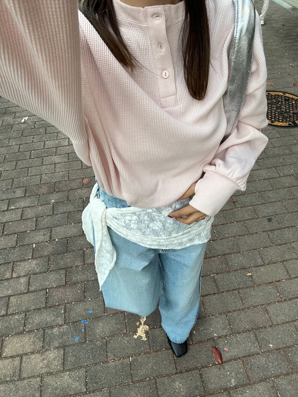 ブルー系のデニムパンツ、ブラック系のサンダル、シルバー系のハンドバッグを着用したレディースの冬コーディネートの8枚目の写真