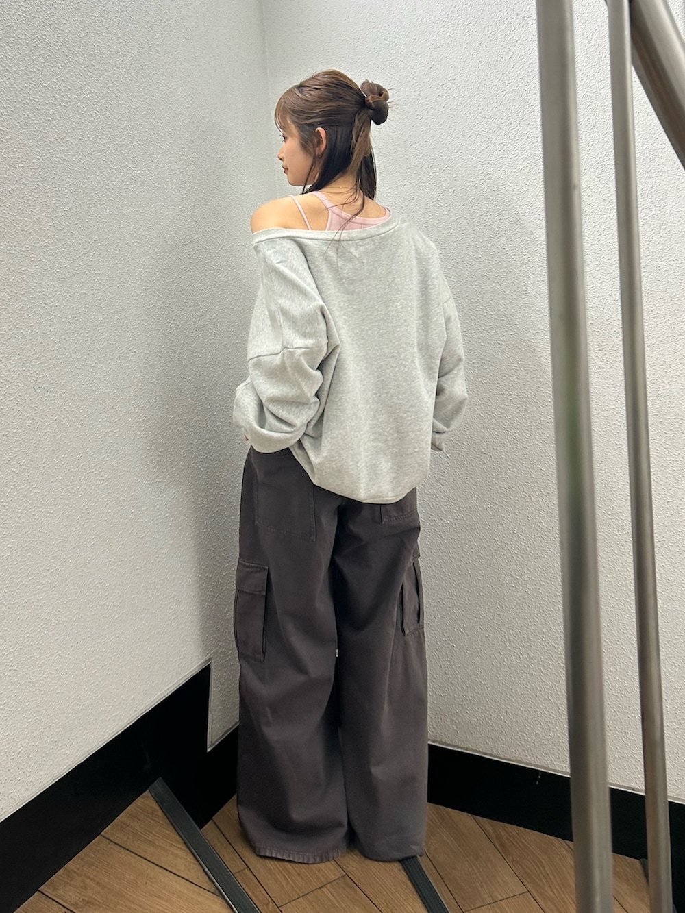 グレー系のスウェット、ブラウン系のカーゴパンツ、ピンク系のキャミソールを着用したレディースの春コーディネートの3枚目の写真