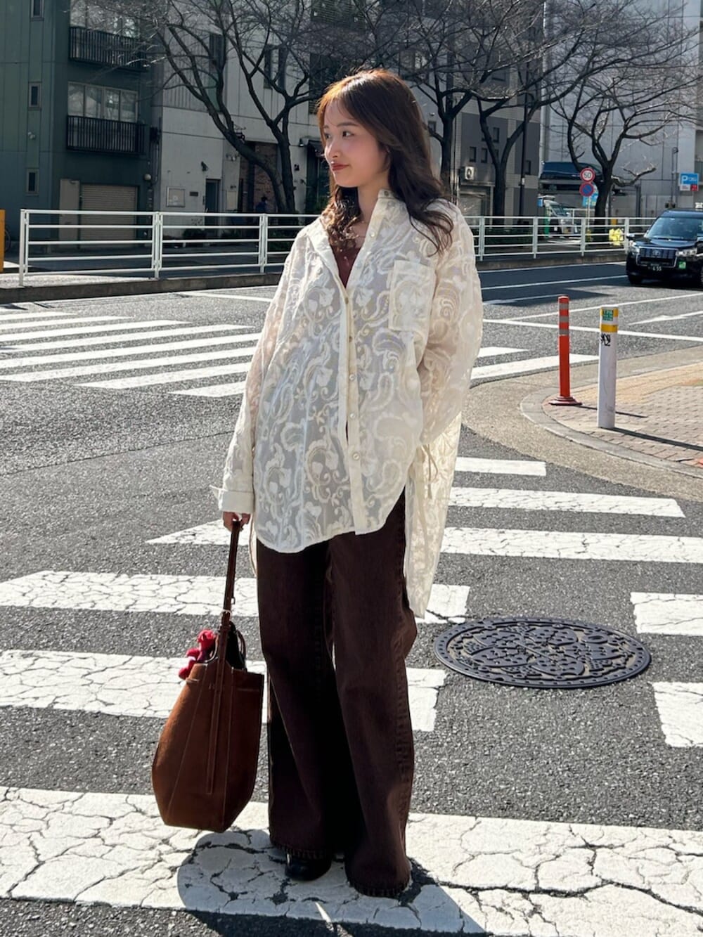 ブラウン系のキャミソール、ホワイト系のシャツ/ブラウス、ブラウン系のデニムパンツを着用したレディースの春コーディネートの2枚目の写真